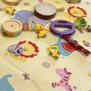 Tambourines and rattles sitting on a baby's playmat decorated with jungle animals