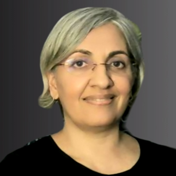 The head of a woman facing the camera. She has short hair, glasses and wears a black top